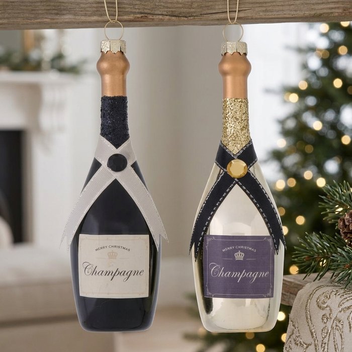 Two hand-painted glass champagne bottle Christmas ornaments in black, white, gold and clear finishes hanging together