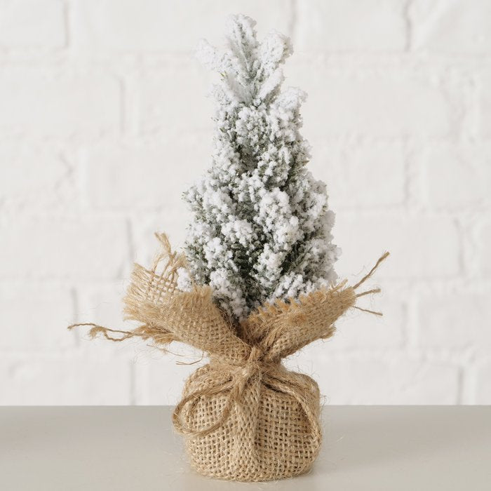 Heavily snow-covered miniature Christmas tree decoration with a rustic jute-wrapped base