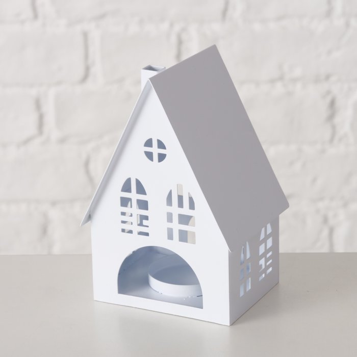Close-up of small white metal house lantern showing arched window and circular cut-out details