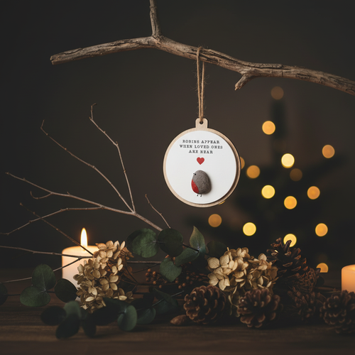 Robins appear when loved ones are near hanging sign styled with candlelight and winter botanicals in a Nordic Christmas setting