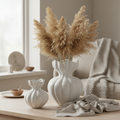 Two white sculpted ceramic vases styled in a beautiful Nordic home setting